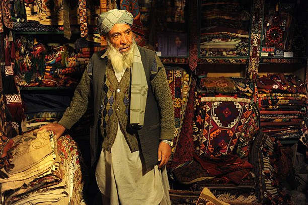 KABUL, AFGHANISTAN - OCTOBER 17: An Afghan shopowner selling Afghan carpets and rugs seen in his shop in Chicken Street on October 17, 2011 in Kabul, Afghanistan. Chicken Street has been a focus for Afghanistan’s tourists since the days of the Hippy Trail. All kinds of handicrafts are available here, from jewellery to carpets, ‘antique’ muskets to poached furs. (Photo by Kaveh Kazemi/Getty Images)